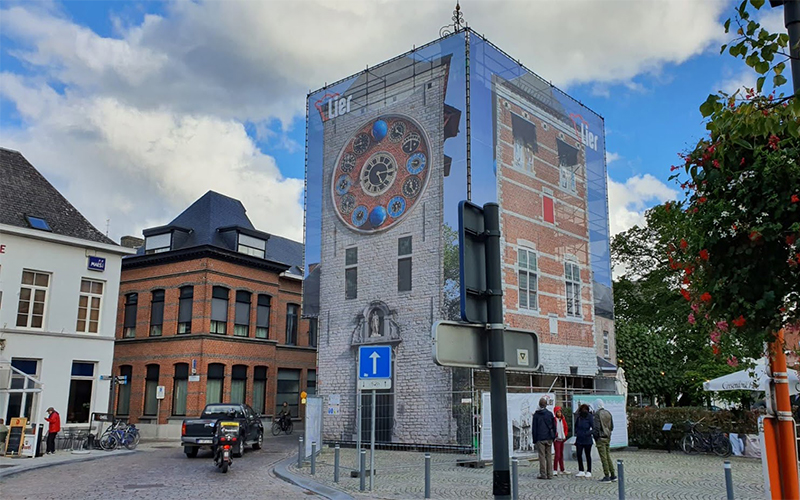 Er hangen banners rond een toren die verbouwd wordt.