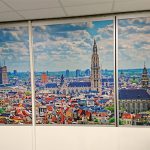 All_Signs_raamsticker_indoor_stad_Antwerpen2 Sticker van een foto van stad Antwerpen die aan de binnenkant van een kantoorruimte is gekleefd.