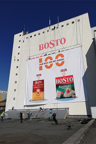 Een spandoek wordt opgehangen aan de Bostotoren.